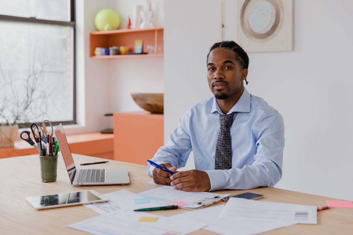 Confident professional working at his desk after fixing the bad breath affecting his career and promotions