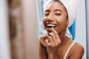 Cheerful woman flossing her teeth as part of her daily oral care routine