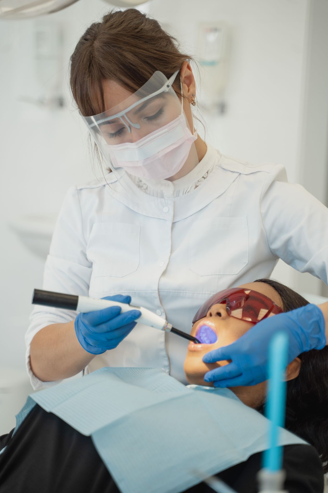 Oral Probiotics for Cavities 1 Dentist using a dental curing light on a patient during treatment, related to repairing cavities and tooth decay