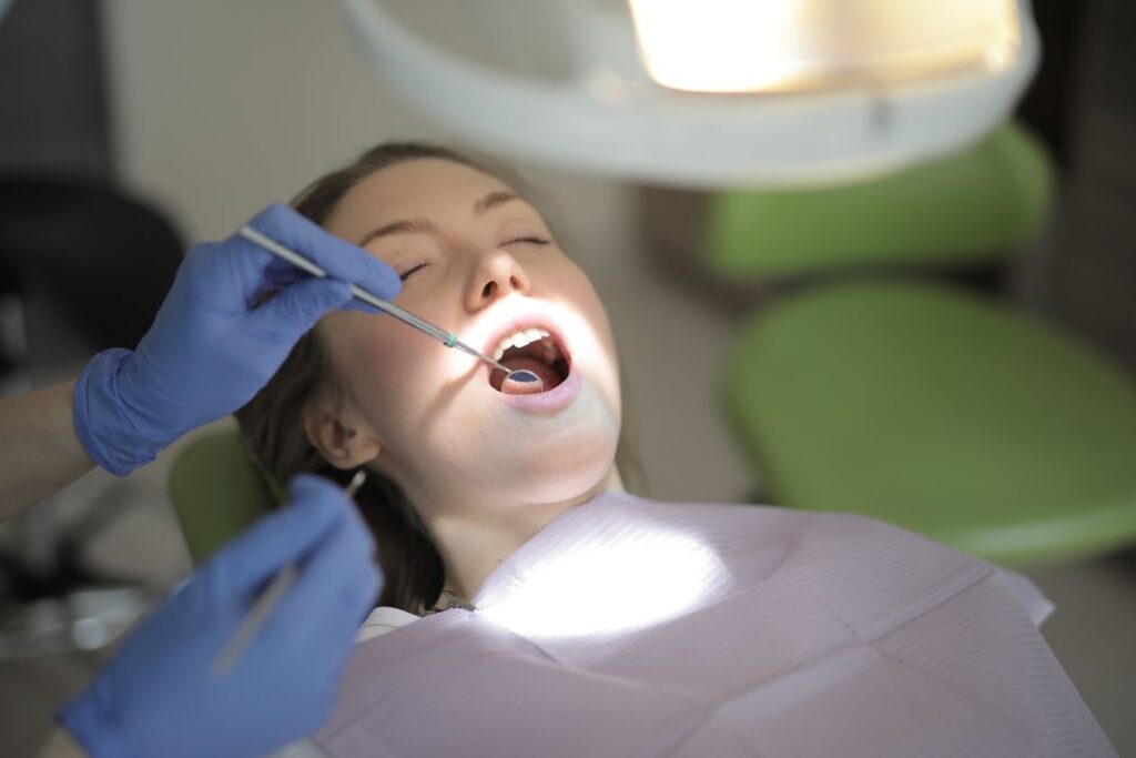 Dentist in latex gloves examining a patient's teeth in a clinic, related to choosing the best probiotics for oral health