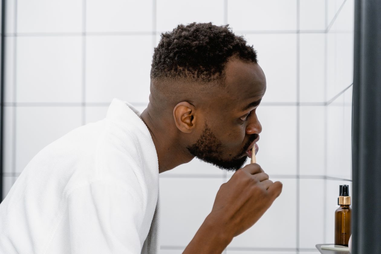 Why Does My Breath Smell After Brushing and Flossing? 1 A man in a white robe brushing his teeth in the morning as part of his oral care routine