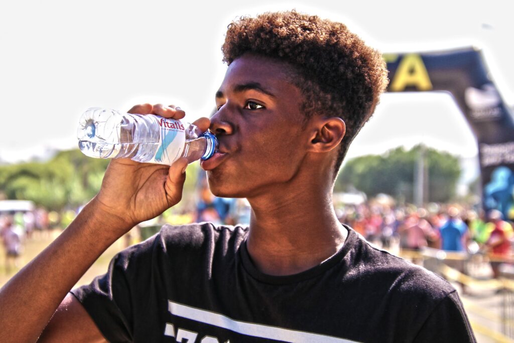 Man drinking water to hydrate and support oral health and salivary gland function