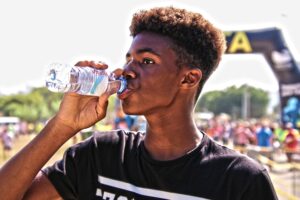 Man drinking water to hydrate and support oral health and salivary gland function