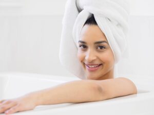 Relaxed woman with a towel turban during her self-care and oral care routine