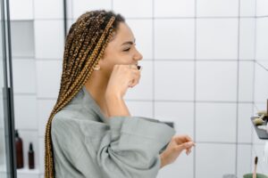 Woman brushing her teeth to help remove plaque and keep her mouth healthy