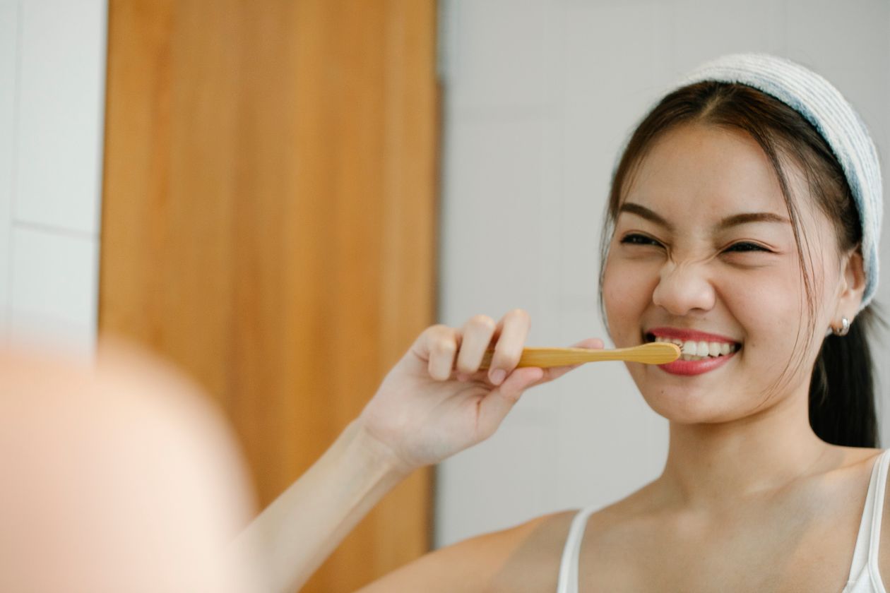 Why Is My Tongue White? 1 Positive woman brushing her teeth as part of a daily oral care routine that helps prevent a white tongue