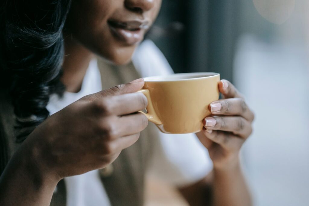 Woman holding a cup of coffee, the daily habit behind coffee breath