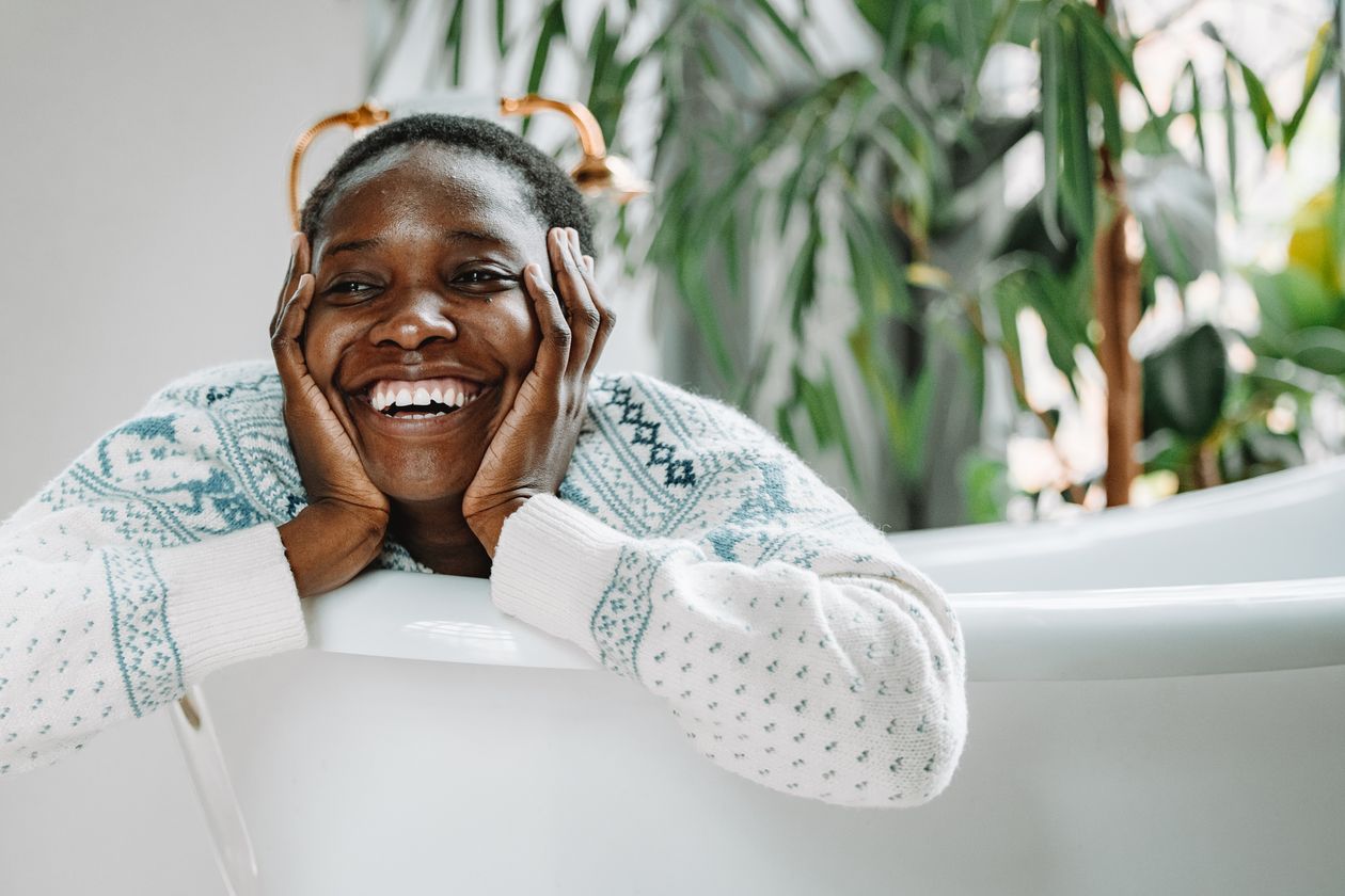 Woman in a sweater relaxing, taking a moment for her daily self-care and oral health routine