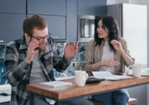 Anxious person sitting beside their partner trying to find the words to tell someone they have bad breath