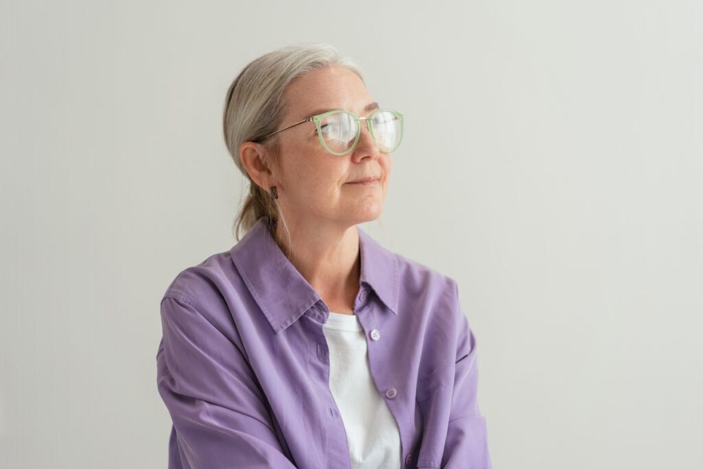 Composed grey-haired woman in eyeglasses, managing bad breath during perimenopause and menopause