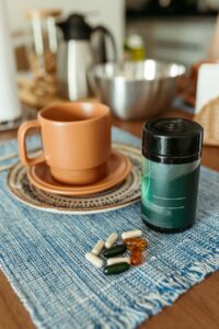Supplements and a cup on a kitchen table, part of a daily routine when oral probiotics are not working yet