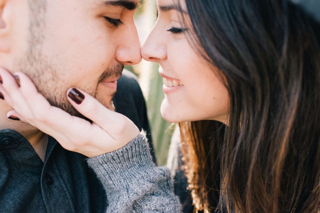 Couple touching noses closely, showing how bad breath is contagious between partners through saliva