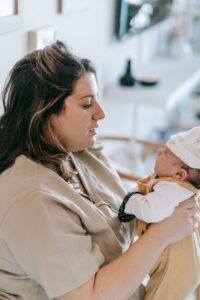 New mother holding her newborn at home, dealing with bad breath during pregnancy and after birth