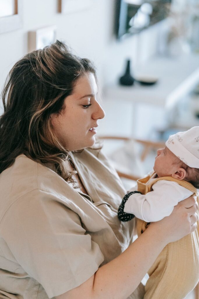 New mother holding her newborn at home, dealing with bad breath during pregnancy and after birth