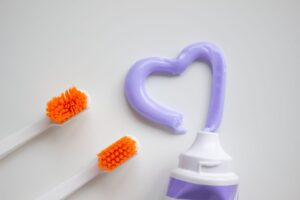 Toothbrushes and toothpaste laid out on a white surface, comparing what to buy for bad breath