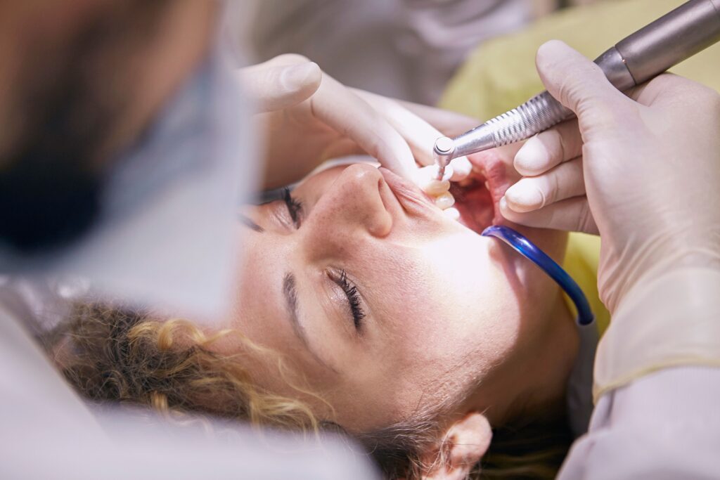 Dental hygienist cleaning a woman's teeth during a routine appointment