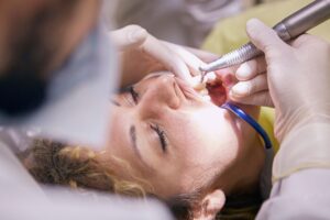 Dental hygienist cleaning a woman's teeth during a routine appointment
