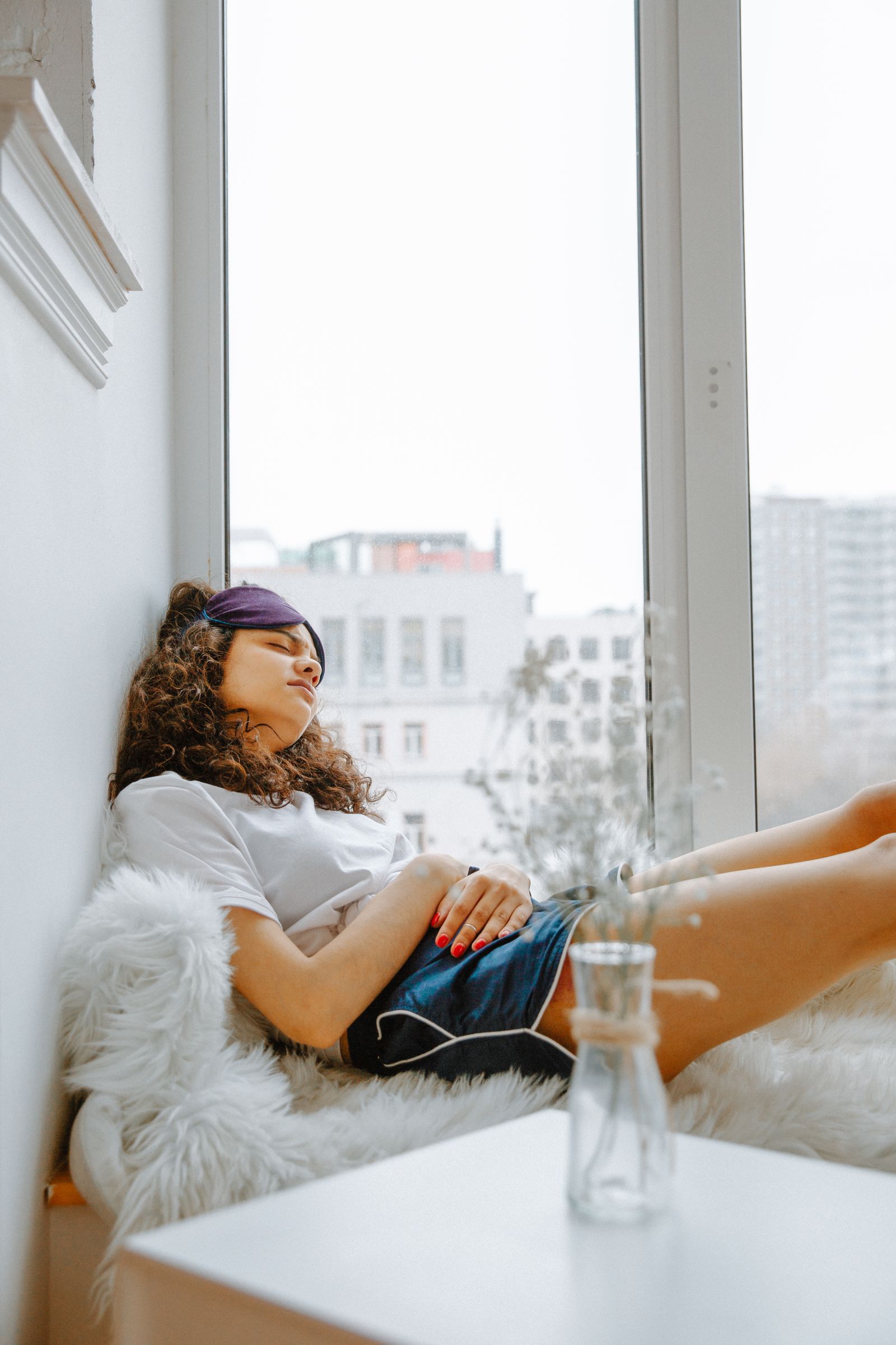 Bad Breath Before Your Period? Why It Happens and How to Fix It 1 Woman resting on the couch with period cramps, noticing bad breath before her period