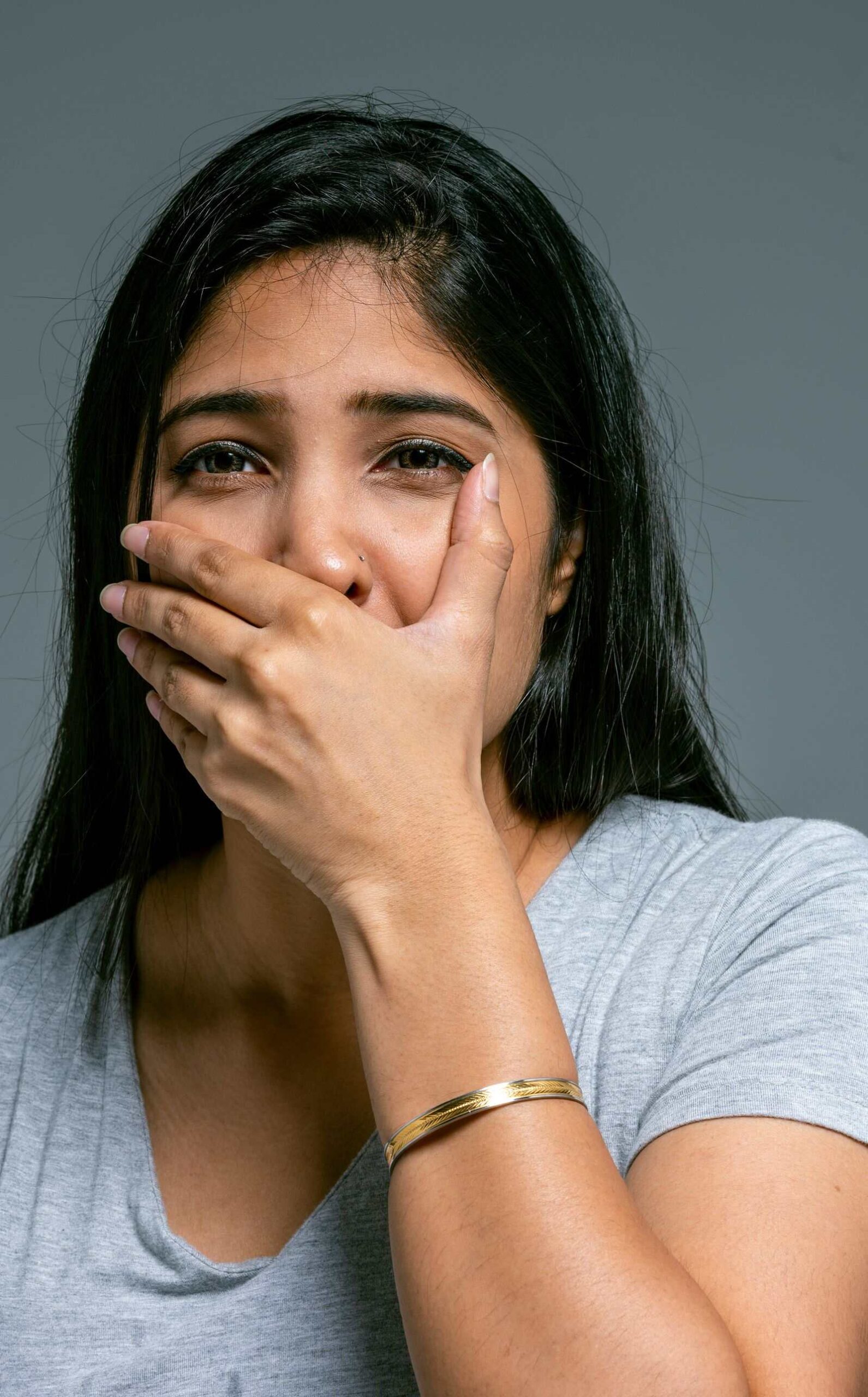 Woman covering her mouth, worried about bad breath on Ozempic or another GLP-1 weight loss medication