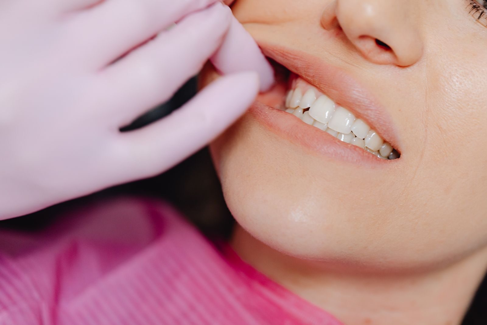 Why Does My Floss Smell Bad? What It Means and How to Stop It 2 Dental professional checking a woman's gums for the bleeding and inflammation behind smelly floss