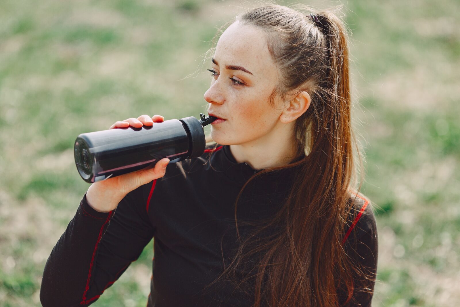 Bad Breath After Working Out? Why It Happens and How to Fix It 2 Sportswoman drinking water outdoors to ease dry mouth during exercise and bad breath